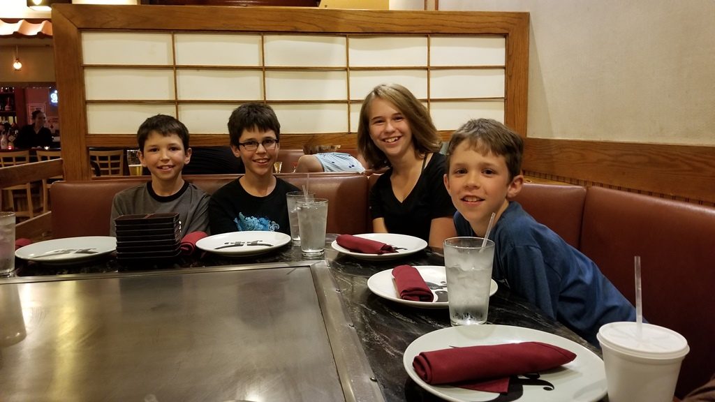 Our kids smiling around the table at dinner